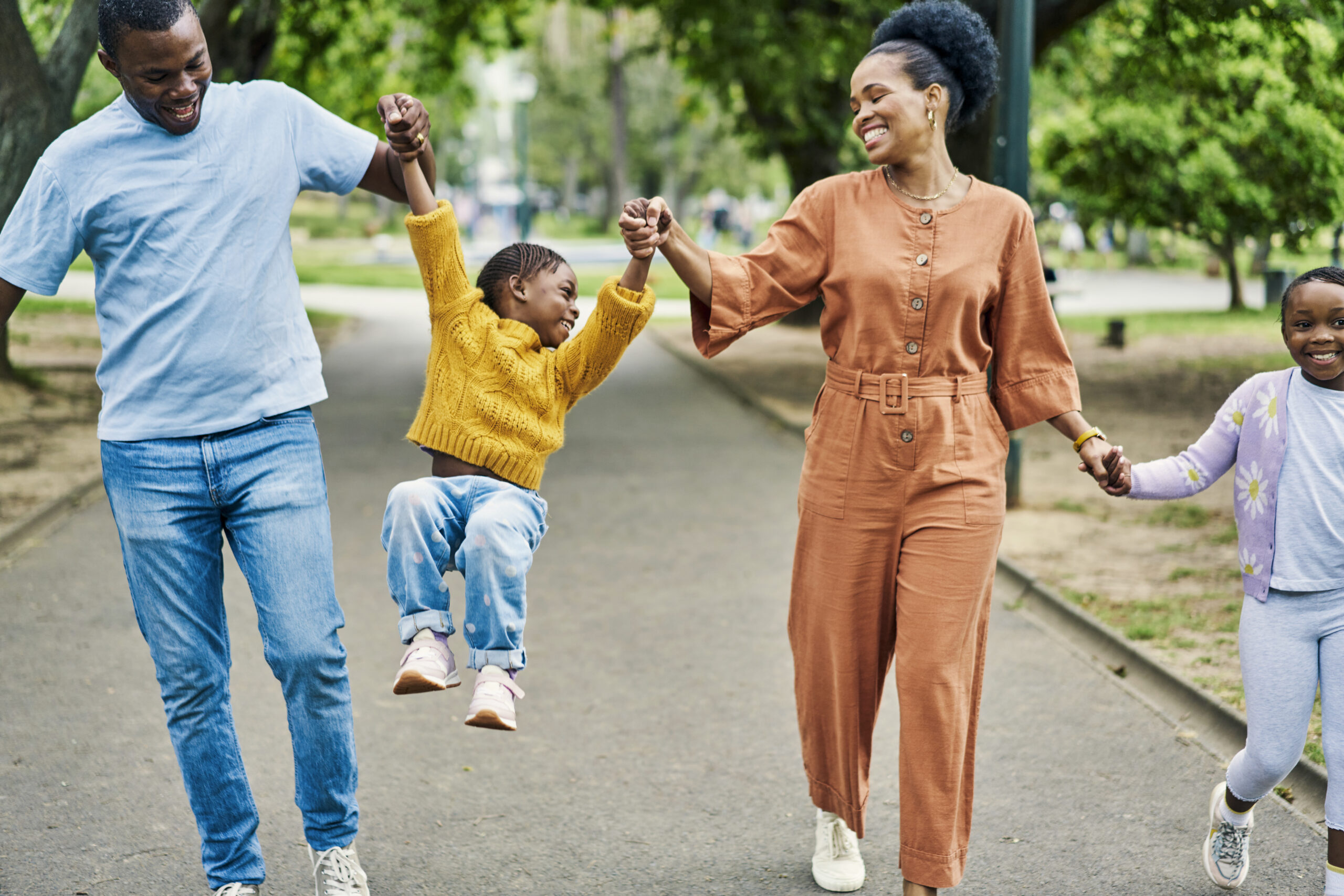 family on walk in park with kids, holding hands and laughing together in nature on weekend